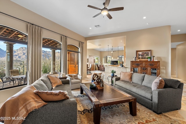 living room featuring a mountain view, plenty of natural light, and ceiling fan