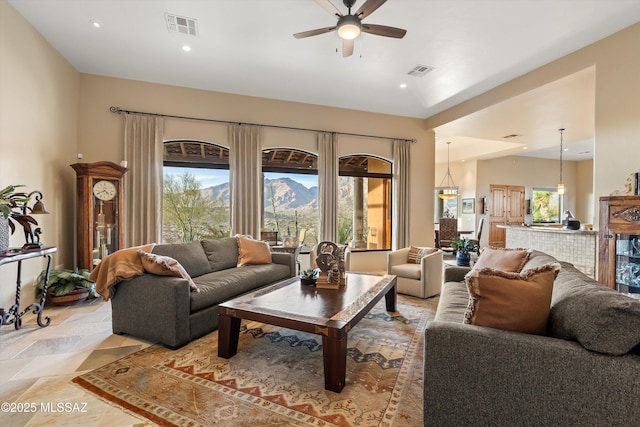 living room with a mountain view, ceiling fan, and a wealth of natural light