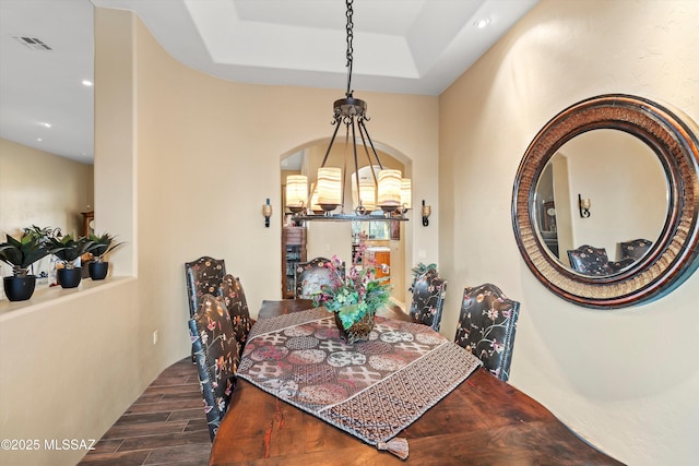 dining room with a tray ceiling and a chandelier