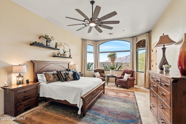 bedroom featuring ceiling fan and a mountain view