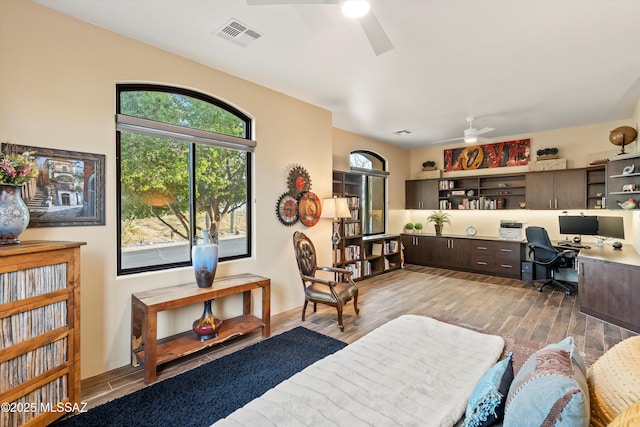 home office featuring hardwood / wood-style flooring, ceiling fan, and built in desk