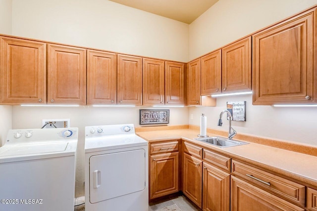 washroom with sink, washing machine and dryer, and cabinets