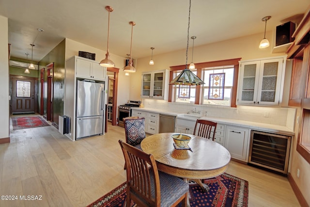 kitchen with white cabinets, appliances with stainless steel finishes, wine cooler, and pendant lighting