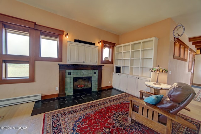 living room featuring a tile fireplace and baseboard heating