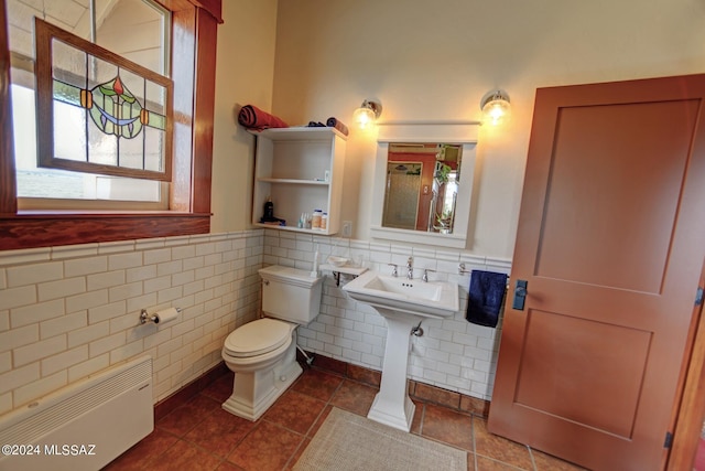 bathroom with tile patterned floors, radiator, tile walls, and toilet