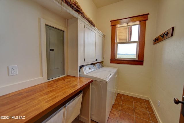 clothes washing area with tile patterned floors, cabinets, electric panel, and washing machine and clothes dryer