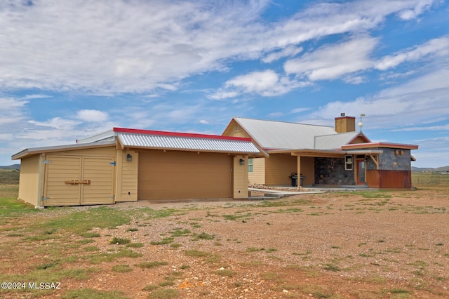 rear view of property featuring an outbuilding