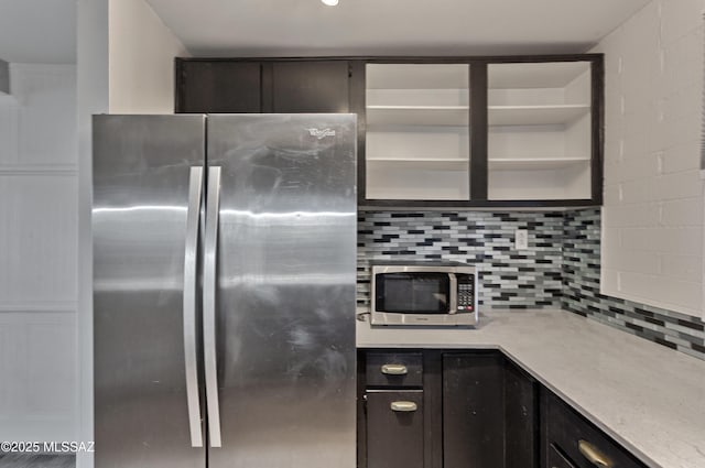 kitchen featuring backsplash, light stone countertops, and stainless steel appliances