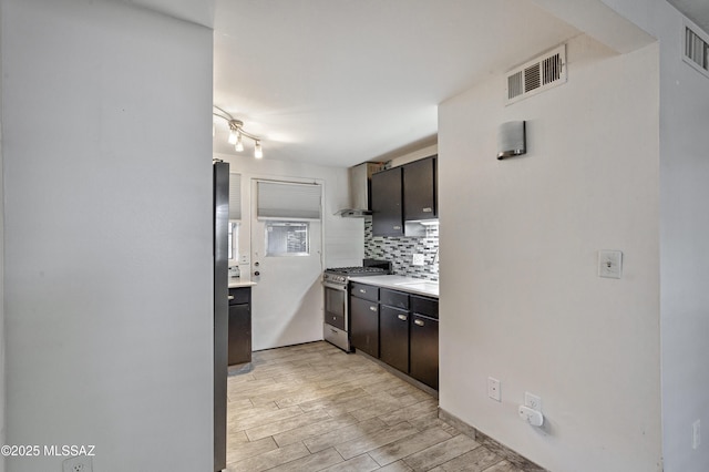 kitchen with dark brown cabinets, tasteful backsplash, sink, and gas range