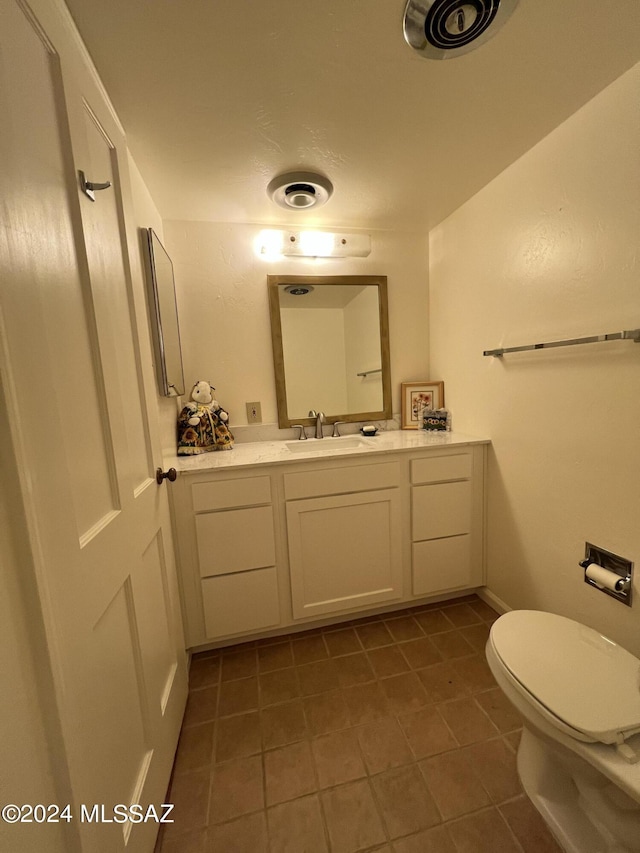 bathroom featuring tile patterned floors, vanity, and toilet