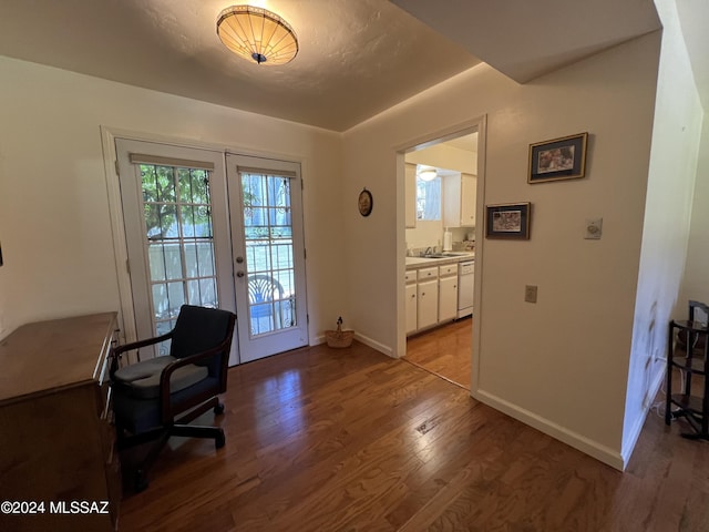 office with light hardwood / wood-style floors and french doors