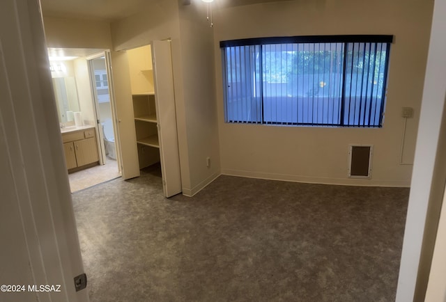 unfurnished room with dark colored carpet