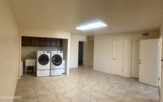 laundry area with cabinets, independent washer and dryer, and sink