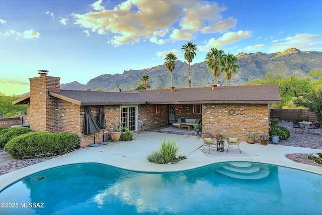 view of swimming pool featuring an outdoor hangout area, a mountain view, and a patio