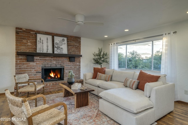 living room with ceiling fan, a fireplace, and hardwood / wood-style flooring