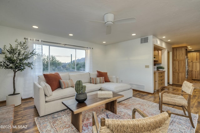 living room with ceiling fan and dark hardwood / wood-style floors