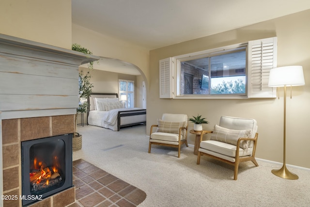 carpeted bedroom featuring a tile fireplace