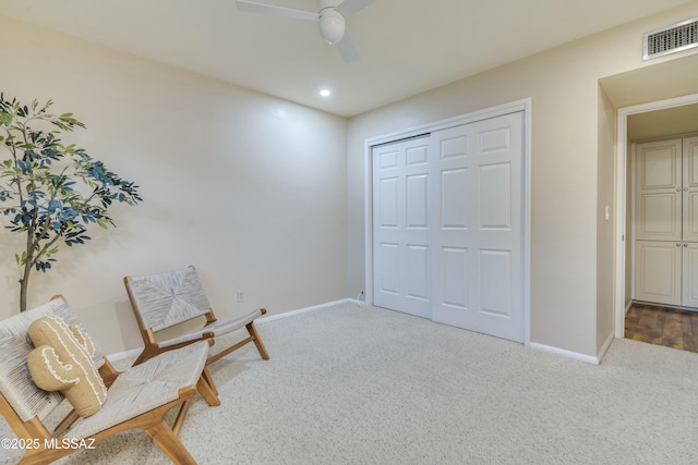 living area featuring ceiling fan and carpet