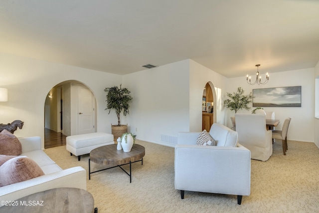 carpeted living room featuring a chandelier