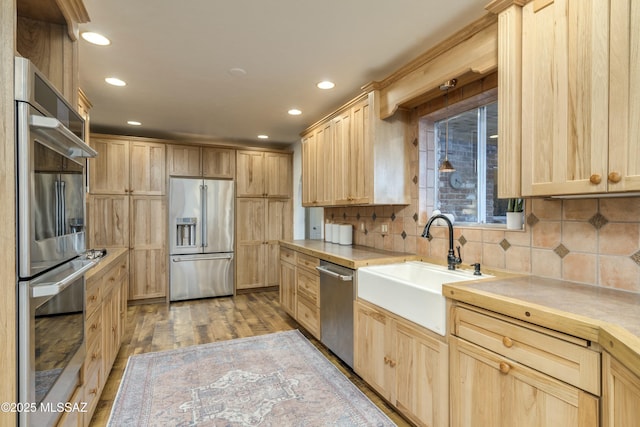 kitchen featuring light wood-type flooring, appliances with stainless steel finishes, and light brown cabinetry