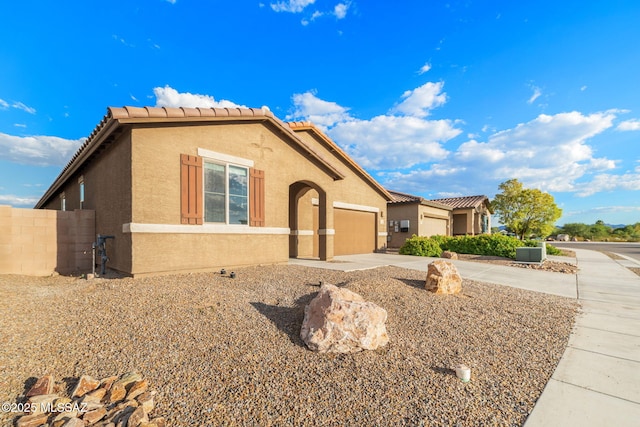 view of front of home featuring cooling unit and a garage