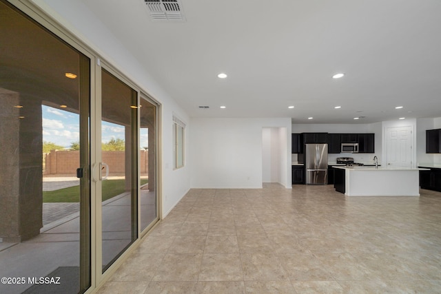 unfurnished living room featuring sink and light tile patterned floors