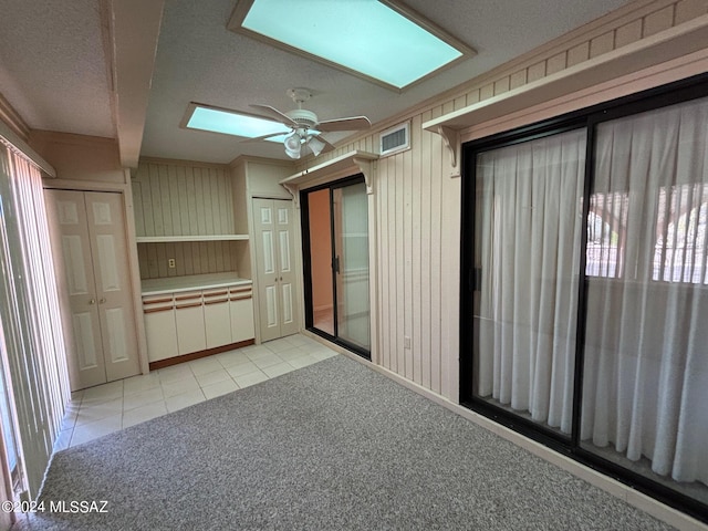 interior space featuring beam ceiling, a skylight, and ceiling fan