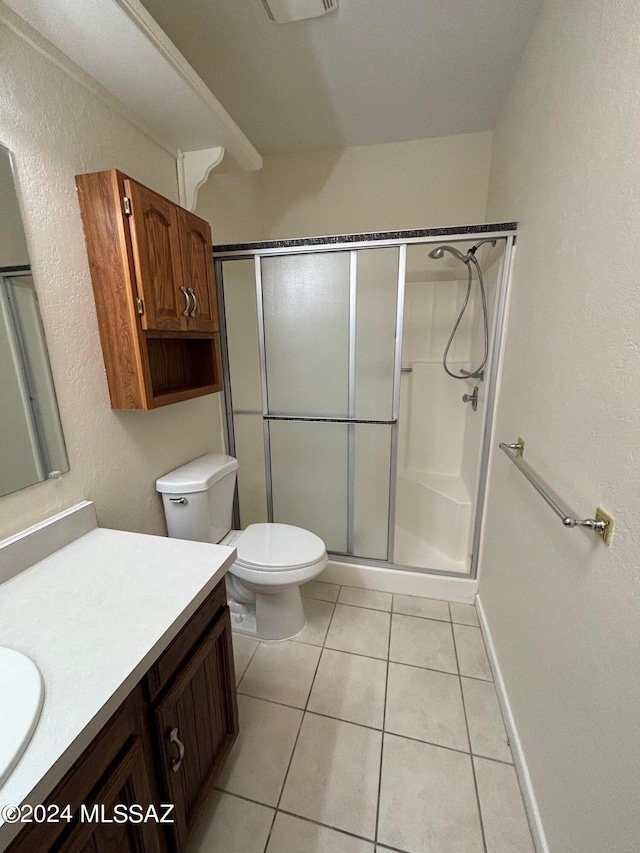 bathroom featuring tile patterned floors, vanity, toilet, and walk in shower