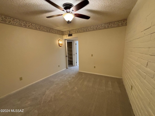 spare room with ceiling fan, carpet floors, and a textured ceiling