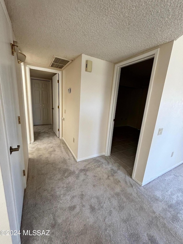 carpeted spare room featuring a textured ceiling