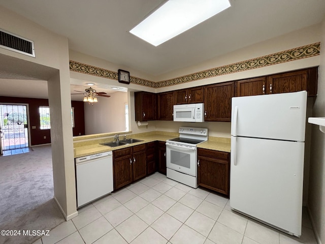 kitchen with dark brown cabinetry, ceiling fan, sink, white appliances, and light carpet