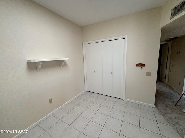 unfurnished bedroom with light tile patterned floors and a closet