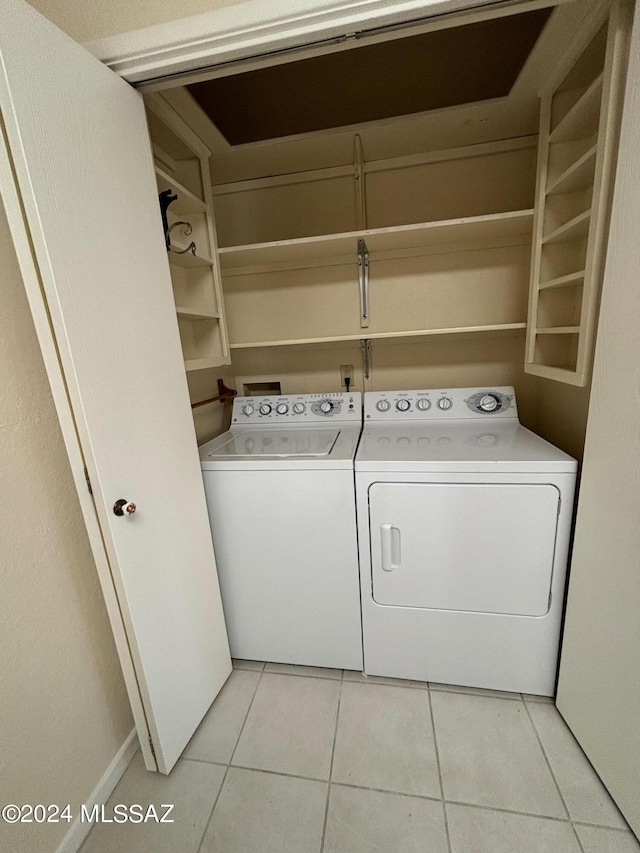 laundry room featuring washing machine and dryer and light tile patterned floors