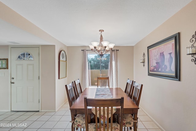 tiled dining room featuring a textured ceiling and an inviting chandelier