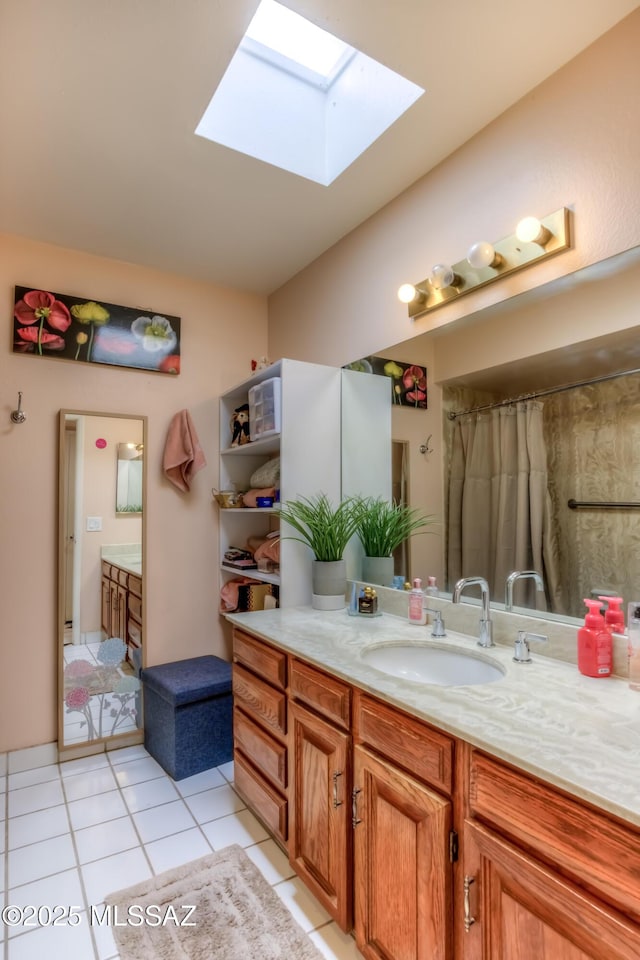 bathroom featuring tile patterned flooring, vanity, and a skylight