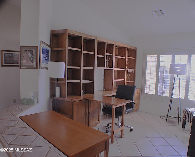 office space featuring light tile patterned floors and vaulted ceiling