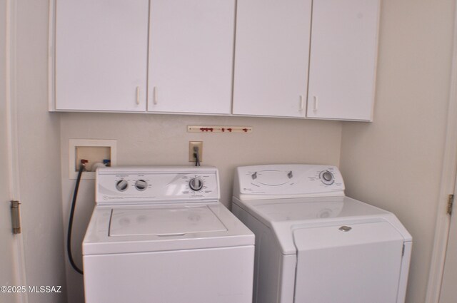 clothes washing area featuring cabinets and washing machine and dryer