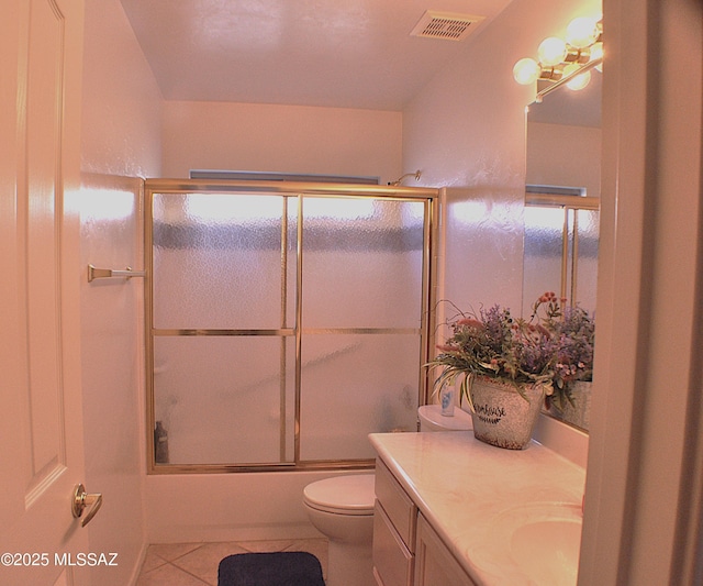 full bathroom featuring tile patterned flooring, vanity, toilet, and combined bath / shower with glass door