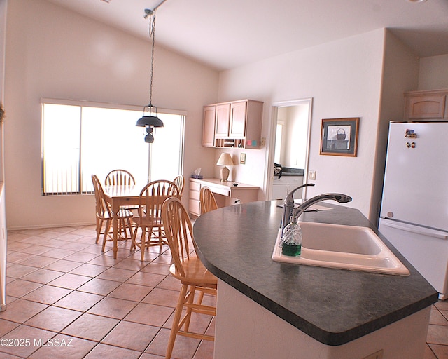 kitchen with light tile patterned flooring, pendant lighting, white fridge, and sink