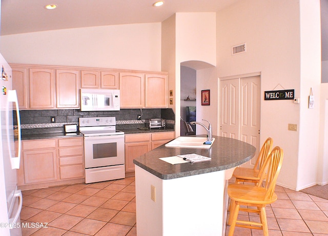 kitchen with light brown cabinets, light tile patterned flooring, white appliances, and sink