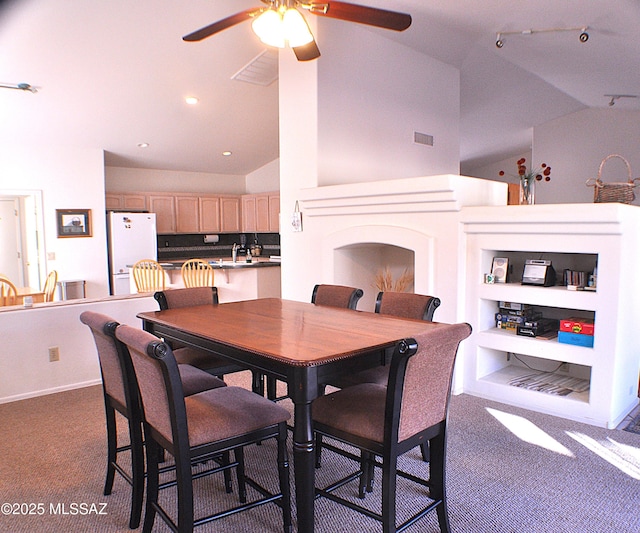 carpeted dining room featuring ceiling fan, built in features, and vaulted ceiling