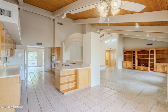 kitchen with beamed ceiling, ceiling fan, wood ceiling, and light brown cabinetry