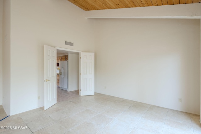 tiled empty room featuring wooden ceiling and lofted ceiling