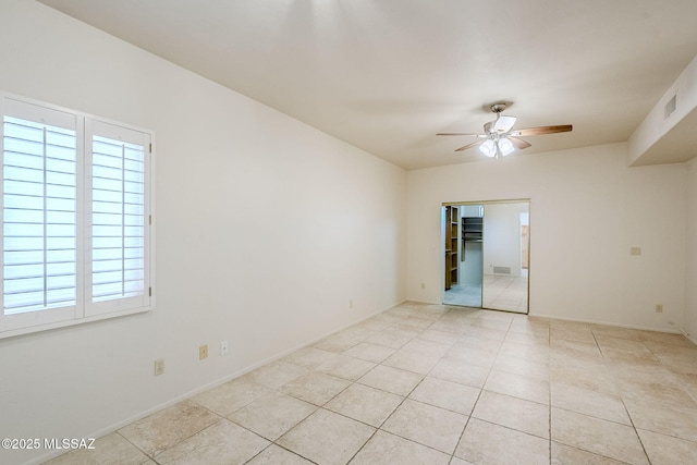 tiled empty room with ceiling fan