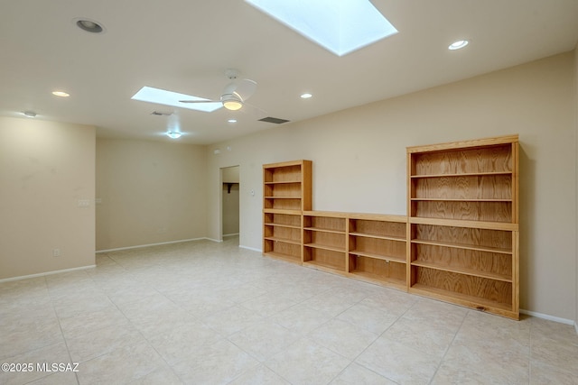 unfurnished room featuring ceiling fan and a skylight