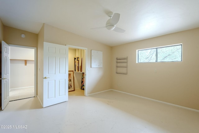 unfurnished bedroom featuring a walk in closet, ceiling fan, a closet, and ensuite bathroom