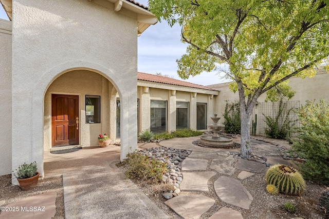 view of exterior entry featuring a patio area