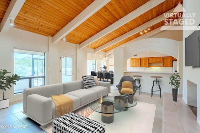 living room featuring light tile patterned floors, vaulted ceiling with beams, ceiling fan, and wood ceiling