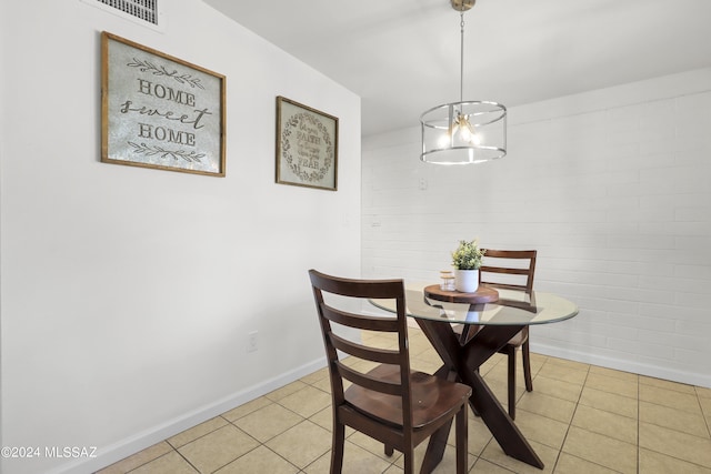 dining area with light tile patterned floors and brick wall