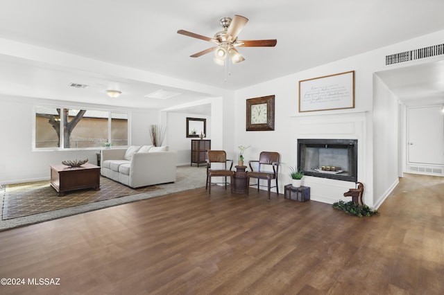 living room featuring ceiling fan and dark hardwood / wood-style floors